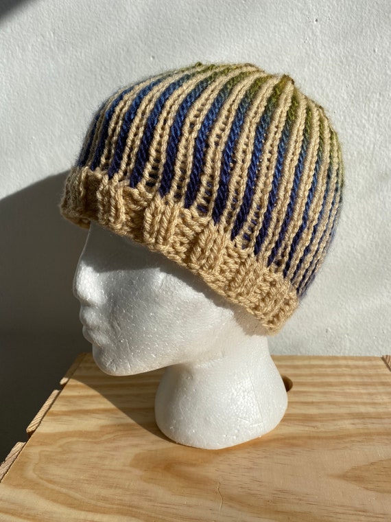 Hand knit brioche stitch beanie hat in cream with navy, forest green, and gold