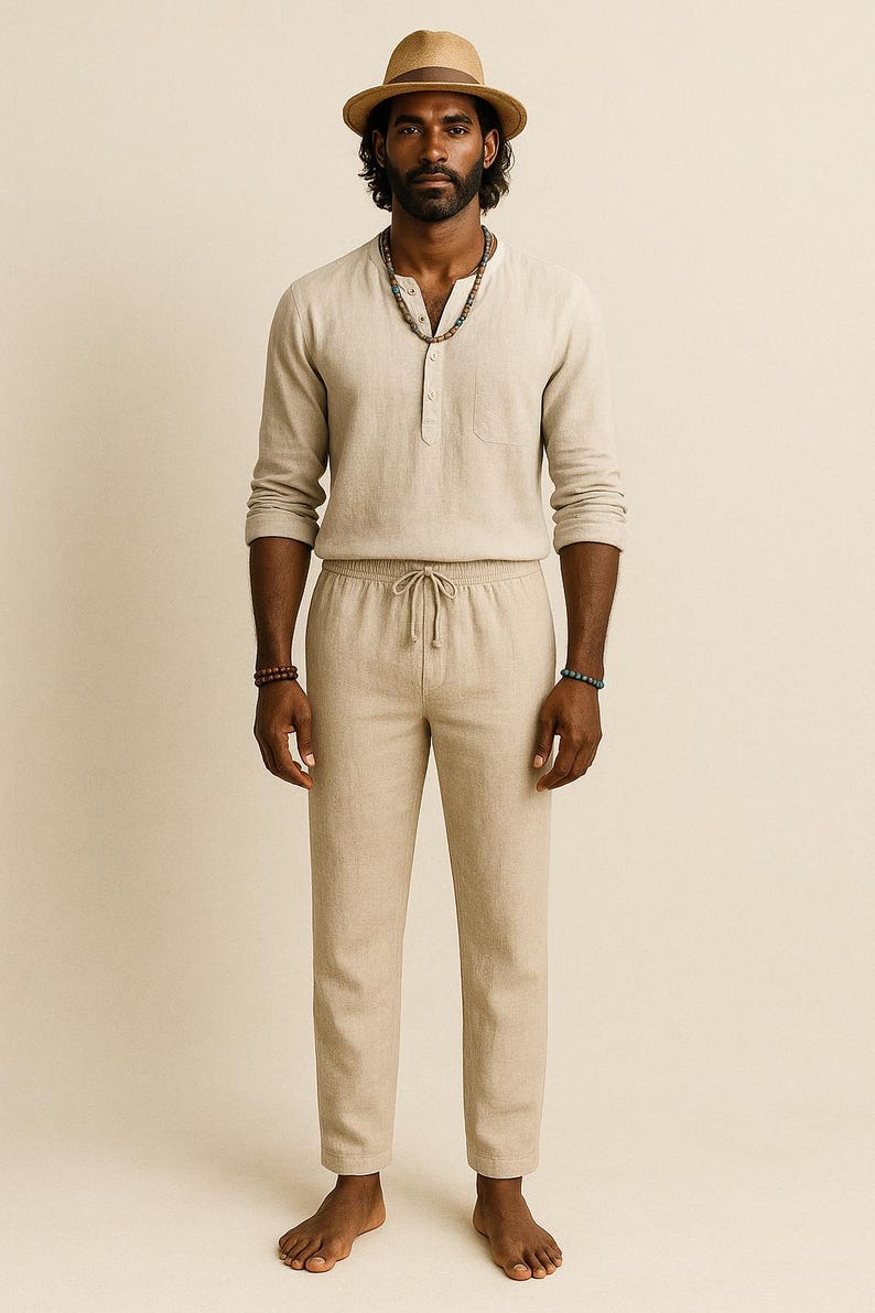 May include: A light beige linen outfit consisting of a long-sleeve Henley shirt, drawstring pants, and a straw fedora hat. The shirt has a single chest pocket. The pants have a relaxed fit. The outfit is suitable for warm weather.