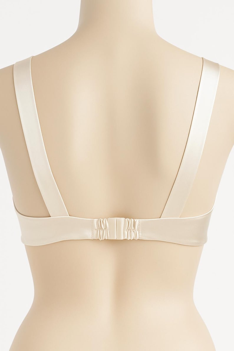 Puede incluir: Un sujetador color crema con tirantes ajustables y cierre de corchete. El sujetador est&aacute; hecho de un material liso, similar al sat&eacute;n. Las correas son anchas y se sujetan a la espalda del sujetador.