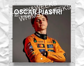 May include: A 2027 wall calendar featuring a portrait of Oscar Piastri wearing an orange and black racing jacket with various sponsor logos. The text OSCAR PIASTRI 2027 CALENDAR is printed in white over the image of the racing driver.