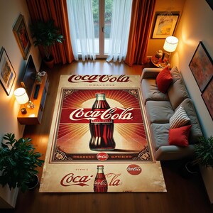 Op de afbeelding: Een vintage Coca-Cola-kleed met een rood, wit en gouden kleurenschema. Het kleed heeft een grote Coca-Cola-fles met de tekst "Coca-Cola" in een vet, rood lettertype. Het kleed heeft ook de tekst "Coca-Cola" in een kleiner lettertype bovenaan en onderaan het kleed.