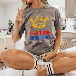 May include: Gray t-shirt with a yellow crown graphic and the text "BEEN THERE DONE THAT (It was revolting)". The shirt is made of a soft material.
