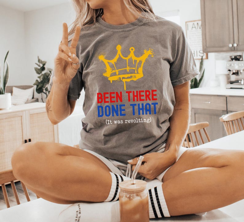 May include: Gray t-shirt with a yellow crown graphic and the text "BEEN THERE DONE THAT (It was revolting)". The shirt is made of a soft material.