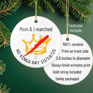 Puede incluir: Adorno navide&ntilde;o de cer&aacute;mica blanca con el texto "Mom & I marched" y "No Kings Day 10/18/25". El adorno presenta una corona dorada con una raya roja. El adorno tiene 7,1 cm de di&aacute;metro.