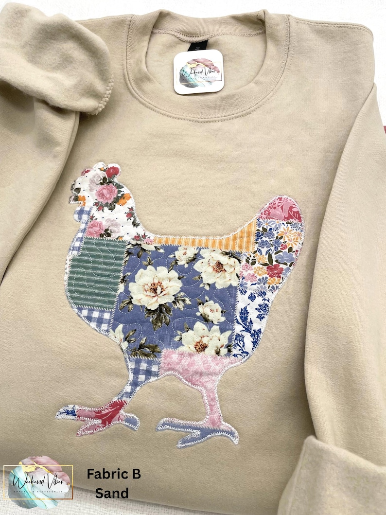 Quilt like printed fabric appliqued on a sand colored Gildan sweatshirt. Sweatshirt has sleeves rolled and is on the applique fabric. Fabric used is "B" cottagecore patchwork fabric.