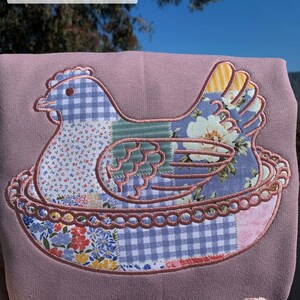 Embroidered Hen on Nest sweatshirt on a Paragon sweatshirt with Fabric G and Mauve thread.