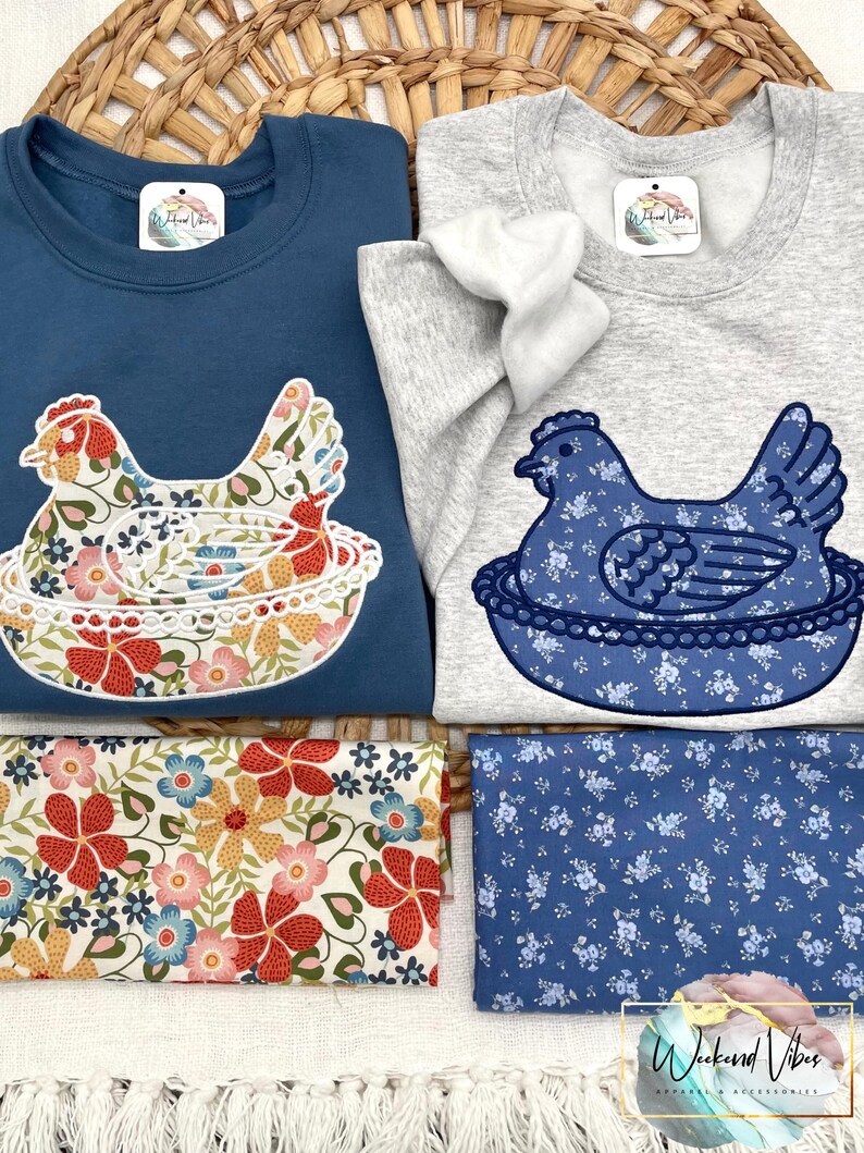 Two Hen on Nest sweatshirts laying on a grass basket with Fabric D and C placed under appliqued nesting chicken.