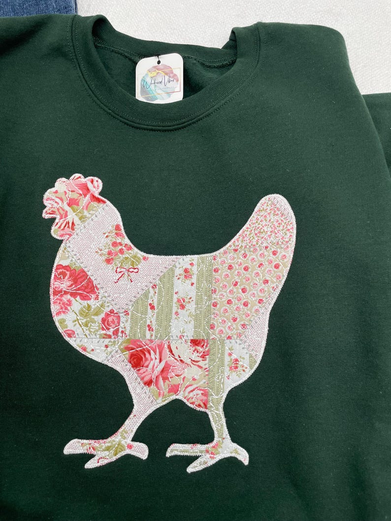 Embroidered chicken on a green sweatshirt. Fabric is a printed patchwork design with shades of pink florals and sage. The appliquéd fabric has a white zigzag border and stippling.
