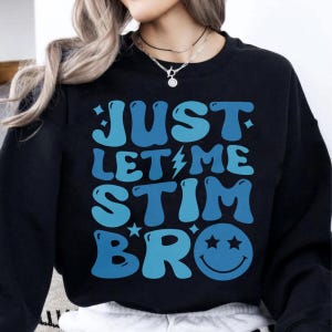 May include: Black sweatshirt with a blue graphic that says "Just Let Me Stim Bro" with a smiley face with two stars for eyes.
