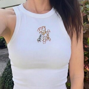 K&ouml;nnte beinhalten: Wei&szlig;es geripptes Tanktop mit einem farbenfrohen, gestickten Design eines Pferdes mit Hut und einem Dalmatiner. Das &auml;rmellose Oberteil ist aus weichem, dehnbarem Material.