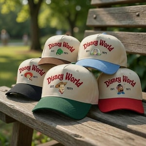 May include: A collection of beige baseball caps with the "Disney World" logo embroidered in red. Each cap features a different colored brim and a character from the Disney franchise. The caps are displayed on a wooden bench.