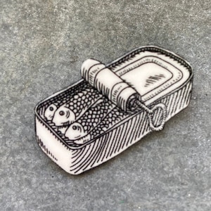 Illustrazione di spilla con sardine in scatola di latta, spilla in acrilico con pesce in scatola