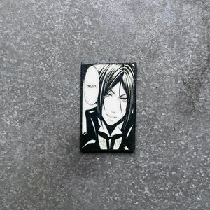 May include: Black and white illustration of a character from the anime series Black Butler. The character has black hair and is wearing a black suit. The character is saying "Dead."