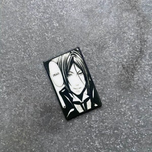 May include: Black and white illustration of a character from an anime or manga series. The character has black hair, a white collar, and a dark suit. The character is looking at the viewer with a smirk. The text "DEAD." is in a speech bubble above the character's head.