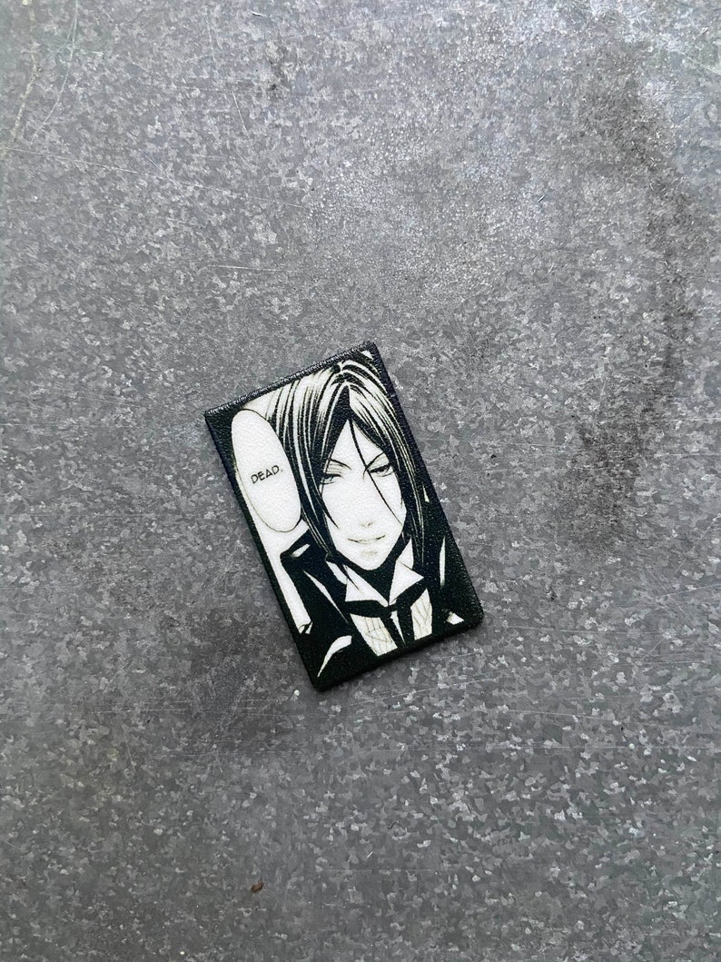 May include: Black and white illustration of a character from an anime or manga series. The character has black hair, a white collar, and a dark suit. The character is looking at the viewer with a smirk. The text "DEAD." is in a speech bubble above the character's head.