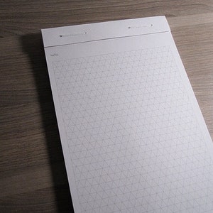 May include: A white notepad with a grid pattern and the word "hello." printed at the top. The notepad has two holes punched at the top and a white string running through the holes.