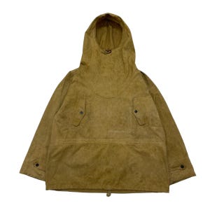 Puede incluir: Chaqueta anorak color beige con capucha. La chaqueta tiene una superficie texturizada, dos bolsillos delanteros y cierres de botón. La capucha es grande y cubre el cuello. La chaqueta tiene un cordón en la parte inferior.