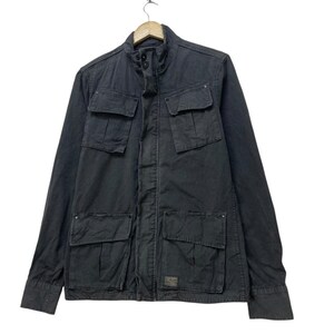 May include: A dark gray jacket with multiple front pockets and a stand-up collar. The jacket has a button-up front and long sleeves. It is hanging on a wooden hanger.