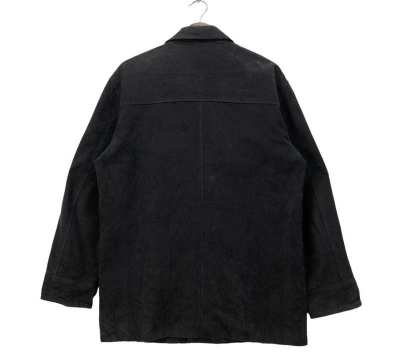 May include: A black long-sleeved jacket with a button-up front and a collar. The jacket is made of a soft, textured fabric.