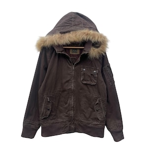 May include: Brown corduroy jacket with a fur-trimmed hood. The jacket features a zip-up front, multiple pockets, and a ribbed hem and cuffs. The hood is a darker brown, and the fur trim is a light brown color. The jacket has a vintage look.