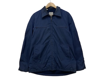 May include: A navy blue jacket with a collared neckline and a full-length zipper. The jacket has two chest pockets and two lower pockets. It is hanging on a wooden hanger.