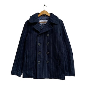 May include: Navy blue pinstripe pea coat with a double-breasted button closure. The coat features a wide collar and a lined interior. The label reads "U.S. 740N". The coat is hanging on a wooden hanger.