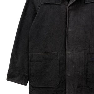 May include: A black long-sleeved jacket with a button-up front and two large pockets. The jacket is made of a thick, textured fabric.