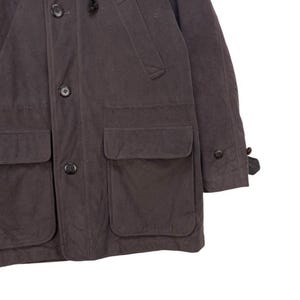 May include: A dark gray hooded jacket with a button closure, two large pockets on the front, and two smaller pockets on the chest. The jacket has a flap on the left sleeve.