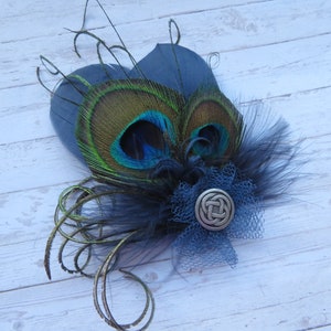May include: A peacock feather hair clip with a blue and green eye, black feathers, and a silver Celtic knot charm.
