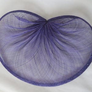 May include: A purple, finely woven, heart-shaped hat made of sinamay.