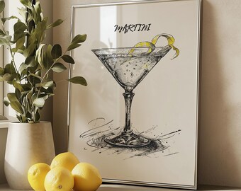 May include: A black and white illustration of a martini glass with a lemon twist, on a white background with the word "Martini" written in cursive. The illustration is framed in a silver frame.