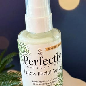 May include: A clear glass bottle of Perfectly Calibrated Tallow Facial Serum with a white pump top. The label includes text and a palm frond design. The words "Grass Fed Tallow" are also visible.