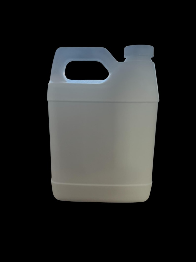 May include: A white plastic jug with a handle and a screw-on cap. The jug is rectangular with rounded corners and a light blue handle. The background is solid black.