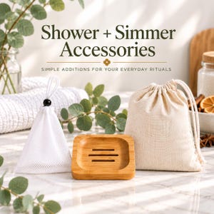 May include: A white mesh pyramid-shaped bag with a drawstring, a square bamboo soap dish with three drainage slots, and a beige cotton drawstring pouch. The text Shower + Simmer Accessories and Simple Additions for Your Everyday Rituals is visible.