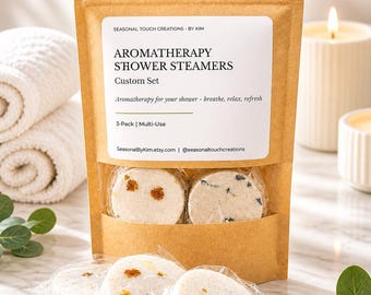 May include: A brown paper pouch containing aromatherapy shower steamers with a label reading SEASONAL TOUCH CREATIONS BY KIM, AROMATHERAPY SHOWER STEAMERS, Custom Set, Aromatherapy for your shower - breathe, relax, refresh, 3-Pack | Multi-Use.