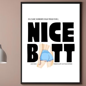 May include: A white poster with black text that reads "IN CASE NOBODY HAS TOLD YOU; NICE BATT AND YOUR PERSONALITY AIN'T BAD EITHER". A woman's back is shown wearing blue denim shorts.