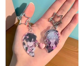 May include: Two anime-style keychains, each in the shape of half a heart, featuring male character illustrations. The keychains are connected by a small pink heart charm. Each keychain has a silver star-shaped clasp.
