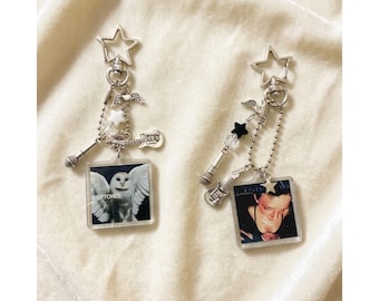 May include: Two keychains with silver star, guitar, and microphone charms. One keychain features a square image of an owl, the other a person. Both have the word "Deftones" on the owl keychain.