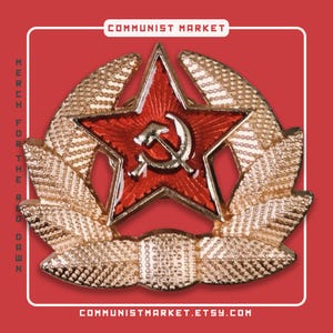 May include: A red star badge featuring a hammer and sickle, encircled by a gold wreath. The text "COMMUNIST MARKET" and "MERCH FOR THE RED DAWN" are displayed. The Etsy shop URL is also visible.