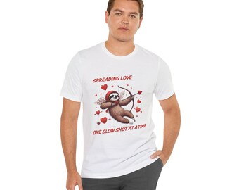 Könnte beinhalten: Weißes T-Shirt mit einem Grafikdruck eines Faultiers, das einen Bogen und Pfeil hält, mit dem Text "Spreading Love One Slow Shot At A Time".