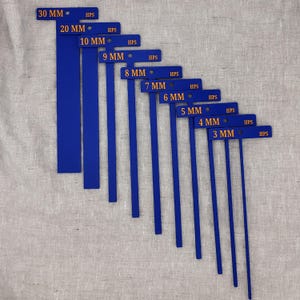 May include: A set of blue metal measuring tools, each with a horizontal bar and a vertical stem. The measurements range from 3 mm to 30 mm, with the text "HPS" on each. The tools are arranged in descending order.