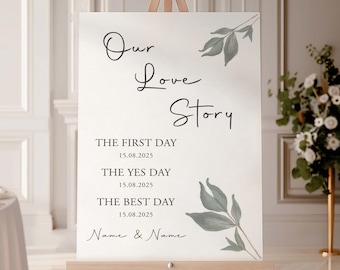 May include: White wedding sign with green foliage and the text "Our Love Story" with dates for "The First Day", "The Yes Day", and "The Best Day".