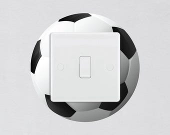 May include: A white light switch with a black soccer ball design. The switch has a single toggle button.