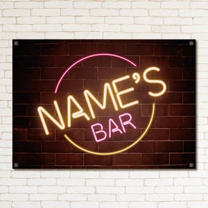May include: A neon sign reading "NAME'S BAR" in a retro style. The sign has a brown brick background and a pink and yellow colour scheme. The sign is mounted on a white brick wall.