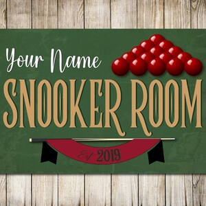 May include: Green sign with the text "Your Name Snooker Room Est. 2019" in gold lettering. A red snooker ball pyramid is at the top of the sign.