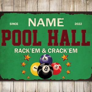 May include: A green and brown vintage-style sign with the text "NAME POOL HALL SINCE 2022 RACK'EM & CRACK'EM". The sign features a green felt background with five gold stars and five billiard balls, including the 1, 3, 4, and 8 balls.