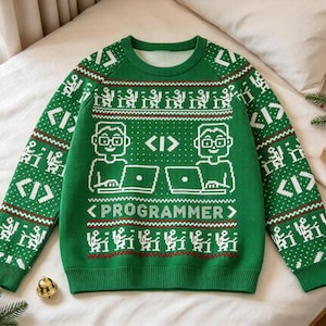 Könnte beinhalten: Ein grüner Langarmpullover mit einem weißen Strickmuster, das Personen an Computern, Code-Klammern und den Schriftzug "PROGRAMMER" auf der Brust zeigt. Das Design enthält sich wiederholende Motive von Figuren an Schreibtischen und geometrische Formen.