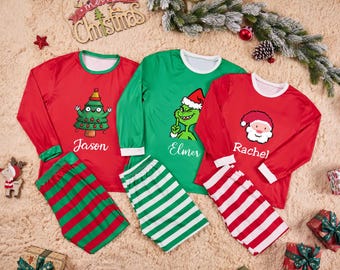 May include: Christmas-themed matching pajama sets in red and green. One set features a Christmas tree graphic with the name "Jason", another has a Grinch graphic with "Elmer", and the last has a Santa graphic with "Rachel".