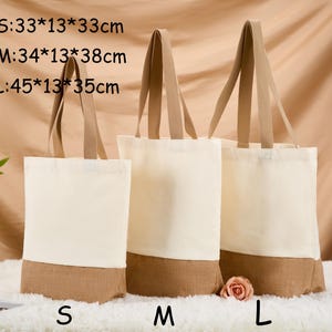 May include: Three canvas tote bags in varying sizes, with beige handles and a natural-colored bottom. The sizes are labeled S, M, and L, with dimensions of 33x13x33cm, 34x13x38cm, and 45x13x35cm respectively. The bags are displayed on a white surface.