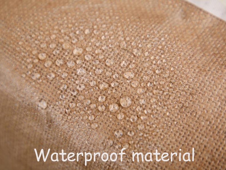 May include: Close-up of a tan, textured fabric with water droplets on the surface. The words "Waterproof material" are written in white at the bottom of the image. The fabric appears to be water-resistant.